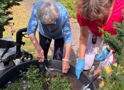 Bewohner der Residenz sind bei der Gartenarbeit behilflich